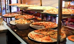 Cheese Pizzas, Wings, Subs, and More at Krispy Krust, Pick-Up and Dine-In if Available (Up to 34% Off)